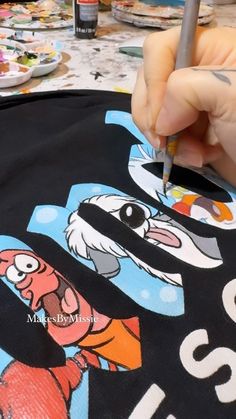 a person is drawing on a t - shirt with a marker