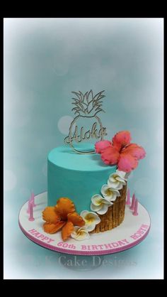 a blue cake with flowers on top and the name aloha written on it