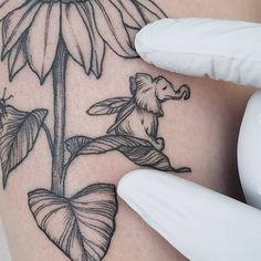 a woman's thigh with a flower and a bee tattoo on her side ribcage