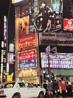 a busy city street at night with neon signs