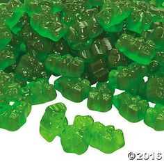 green gummy bears are scattered on a white background