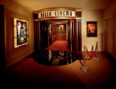 an entrance to a movie theater with red carpet and lights on either side of the door