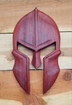 a wooden mask with a red helmet on it