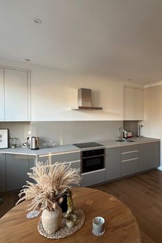 a kitchen with a table, oven and microwave in it's center island area