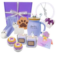 a purple gift box with candles, cupcakes and other items