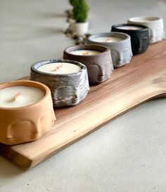 four candles sitting on top of a wooden tray