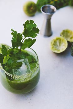 a green drink with cilantro garnish on the rim