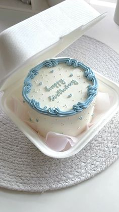 a birthday cake sitting on top of a white plate with blue frosting in the shape of a circle