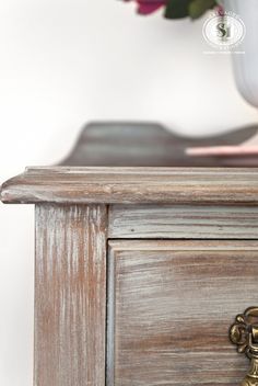 a close up of a drawer with flowers in the background