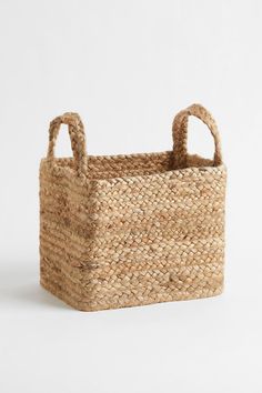 a woven basket with handles on a white background