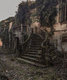 an old abandoned building with vines growing on the walls and steps leading up to it