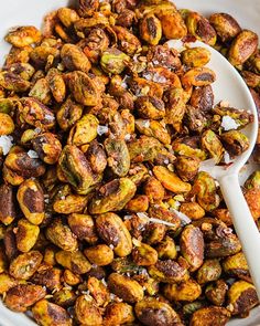 a bowl full of nuts with a spoon in it