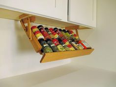 a wooden spice rack with spices and condiments in it hanging from the wall