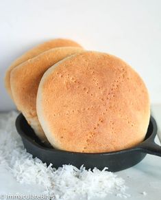 three buns sitting in a skillet on top of white rice