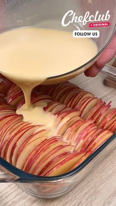 an apple slice being drizzled with cheese sauce in a glass casserole dish