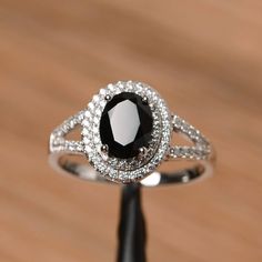 a black and white diamond ring sitting on top of a wooden table