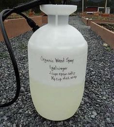 a white jug with writing on it sitting in gravel