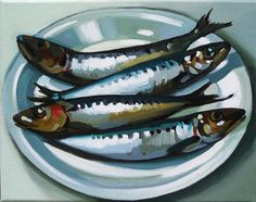 three fish on a white plate sitting on a table