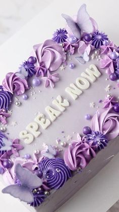 there is a cake decorated with purple flowers and butterflies