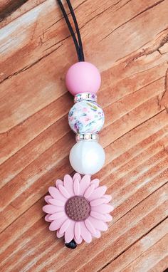 a pink flower is attached to a necklace