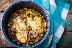 a bowl filled with chicken and mushrooms on top of a blue towel