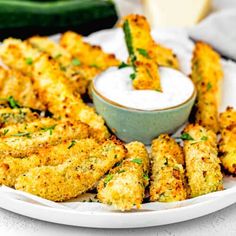 fried zucchini sticks with ranch dressing on a white plate