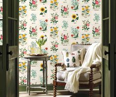 an open door leading to a living room with floral wallpaper