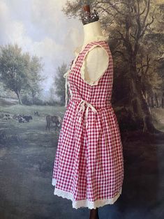 Transport yourself to a charming countryside cottage with our vintage-style red gingham mini dress! Inspired by historical fashion, this dress features delicate ivory lace trim, a button-up bodice, ribbon cinching ties, and a gathered skater silhouette. Sizing: ✧IN Bust Waist Length S 34-35 In. 34-35 In. 34 In. M 36-37 In. 36-37 In. 34.5 In. L 38-40 In. 38-40 In. 35 In. ✧CM Bust Waist Length S 85-87.5 cm 85-87.5 cm 85 cm M 90-92.5 cm 90-92.5 cm 86 cm L 95-97.5 cm 95-97.5 cm 87.5 cm Materials:Outer - 100% CottonLining - 97% Polyester, 7% Spandex Care:Hand wash with color-catcher. Air dry laying flat or hanging. Gingham Mini Dress, Fantasy Shop, Countryside Cottage, Rococo Style, Medieval Fashion, Red Gingham, Edwardian Fashion, Curated Vintage, Baroque Fashion