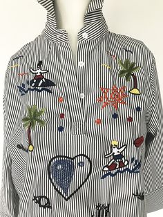 "Cowabunga to clothing in this sweet blue x white striped 2/3\" sleeve popover blouse/ shirt embroidered with a slew of surfers x palm trees. SECTION: NAUTICAL x NANTUCKET MATERIAL: Cotton SIZE: No label, fits M CONDITION: Excellent Vintage Condition No stains, tears, repairs, rips, or holes ✂ - - - MEASUREMENTS: Inches (OBJECT is flat: DBL chest x hem) Chest Width: 20\" Hem Width: 20\" Sleeve Length: 17\" Shoulder-to-Shoulder: 14\" HPS (high point shldr to hem): 28\" ✂ - - - MEASUREMENTS: Centi Oversized Sweater Cardigan, Sleeveless Jumper, Embroidered Shirt, Sweater Vest, Sleeve Cotton, Striped Shirt, White Stripe, Shirt Blouses, Blouses For Women