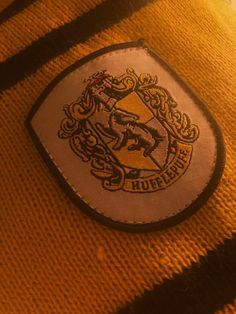 a harry potter badge is shown on the side of a yellow sweater with black stripes