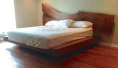 a bed sitting on top of a hard wood floor next to a window with light coming in