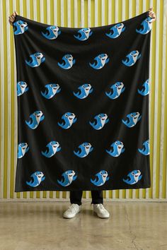 a person holding up a black and blue wallpaper with an image of fish on it