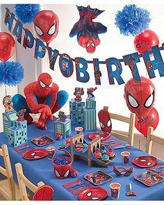 a spiderman birthday party with blue table cloths and decorations, balloons and streamers