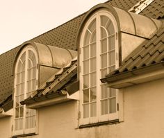 an old building with three windows and a tiled roof