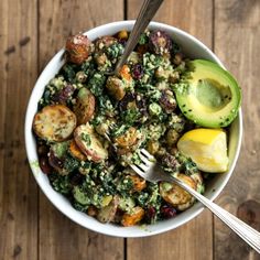 a white bowl filled with vegetables on top of a wooden table next to a fork