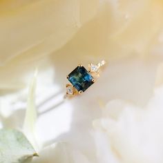 a blue ring sitting on top of a white flower