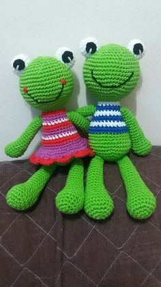 two crocheted frog dolls sitting next to each other