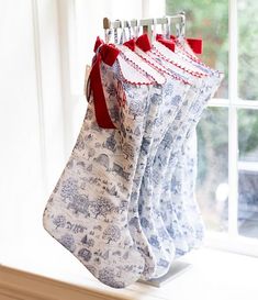 three christmas stockings hanging from a window sill