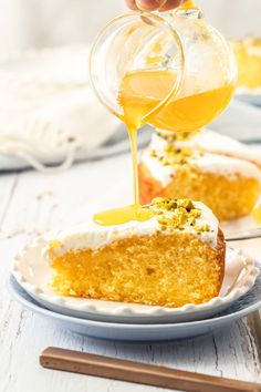 someone pouring honey onto a piece of cake on a plate