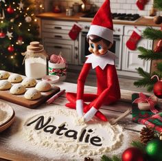 an elf sitting on top of a table next to cookies