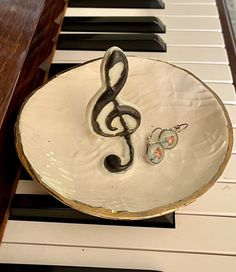 a cake shaped like a treble on top of a piano with an earring