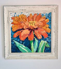 an orange flower is in a white frame