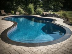 an empty swimming pool surrounded by landscaping