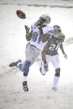 two football players are playing in the snow