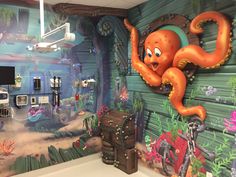 a bathroom with an octopus painted on the wall next to a trunk and other items