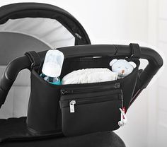 an infant car seat is packed with baby bottles and diapers in it's back pocket