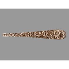 an ornate carved wooden handle on a gray background