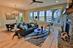 a living room filled with furniture and a fire place in front of a large window