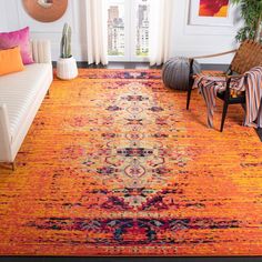 an orange rug in a living room with white walls and furniture, along with colorful throw pillows