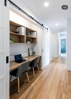 an open door leading to a room with wooden floors and white walls, along with two desks